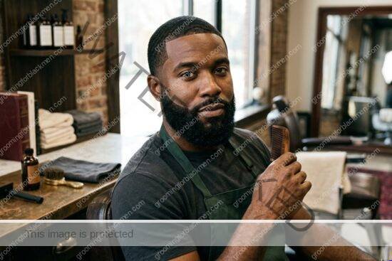 Black man grooming a sharp beard lineup in a premium bathroom setting