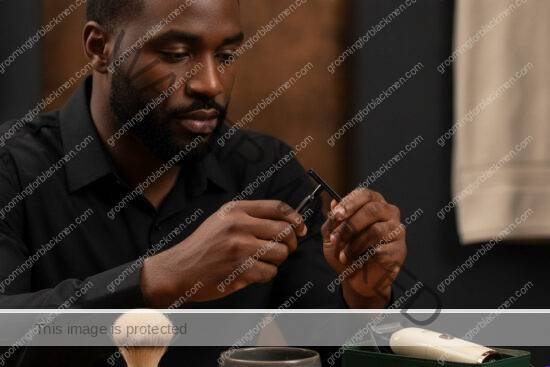 Black man reviewing commercial shaving tools in a premium grooming setting