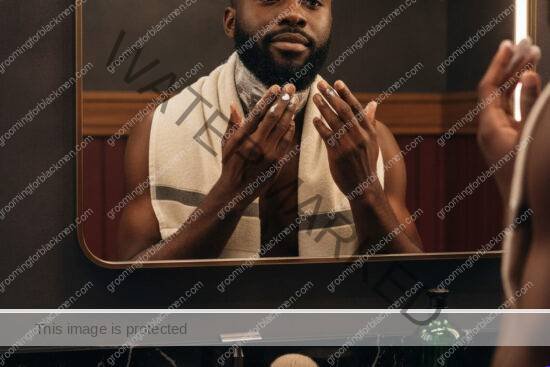 Black man with rich brown skin preparing a gentle shaving routine for sensitive skin
