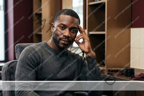 Black man with rich brown skin using budget 360 waves in a premium grooming setting