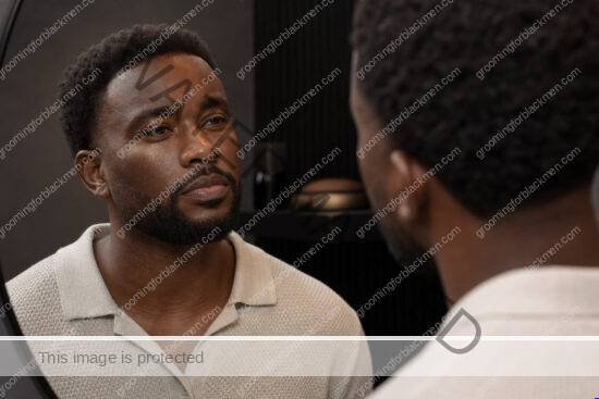 Black man beginning a face looks ashy after moisturizer Black men routine in a premium grooming setting