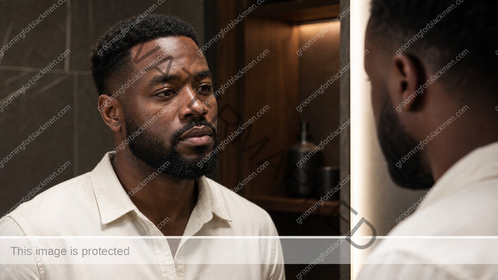 Black man reviewing a niacinamide routine for dark spots and visible oil in a clean grooming setting - Grooming For Black Men