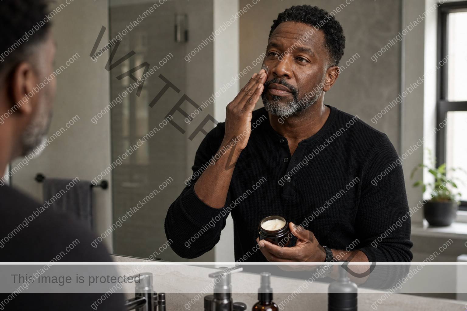 Black man applying moisturizer in a premium under 50 grooming routine